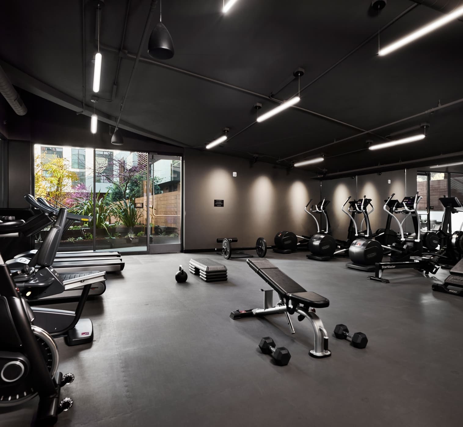 Modern fitness center with strength and cardio equipment in a clean, contemporary residential setting.”
