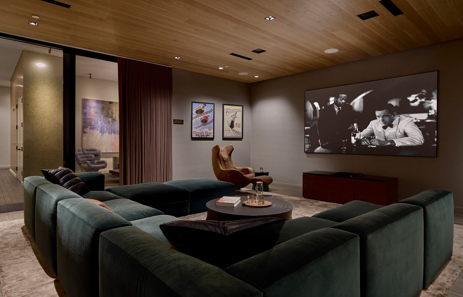 Private screening room with tiered seating and large projection screen in a modern residential building.”