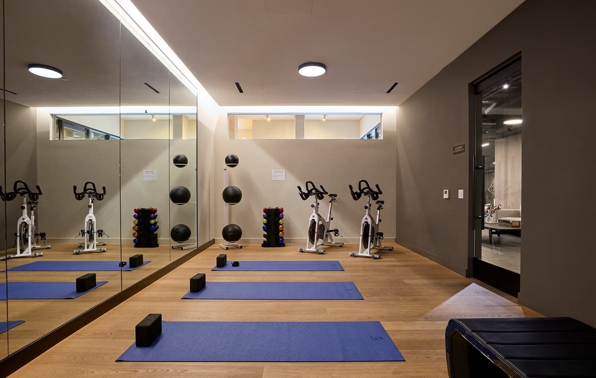 Softly lit yoga studio with open floor space, minimal design, and calming atmosphere for movement and meditation.
